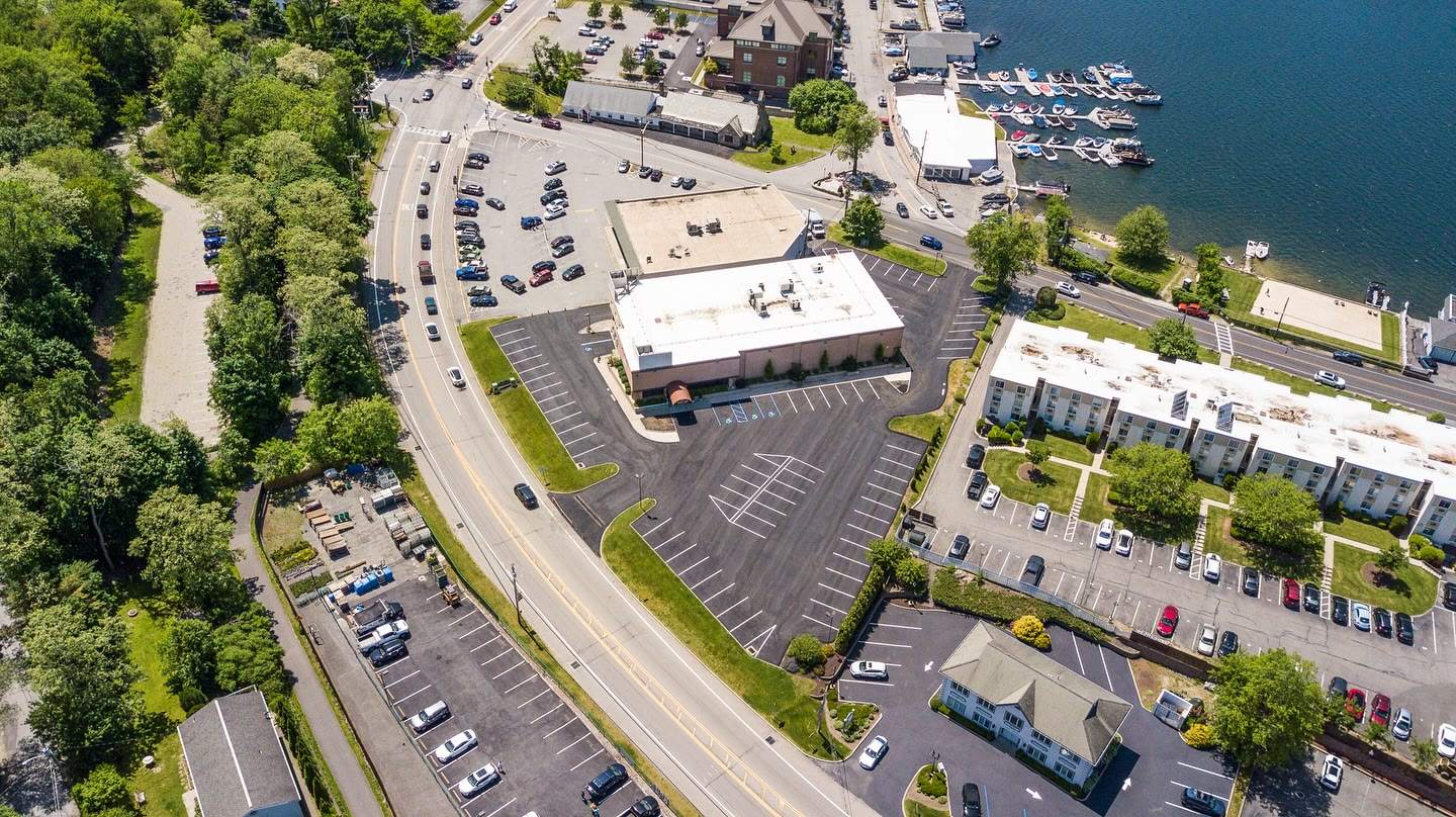 A resurfaced and striped parking lot beside a road, seen from above, a Luxuriad project