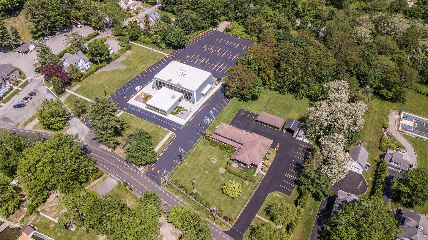 A commercial building and its sealcoated, striped parking lot from above, a Luxuriad project