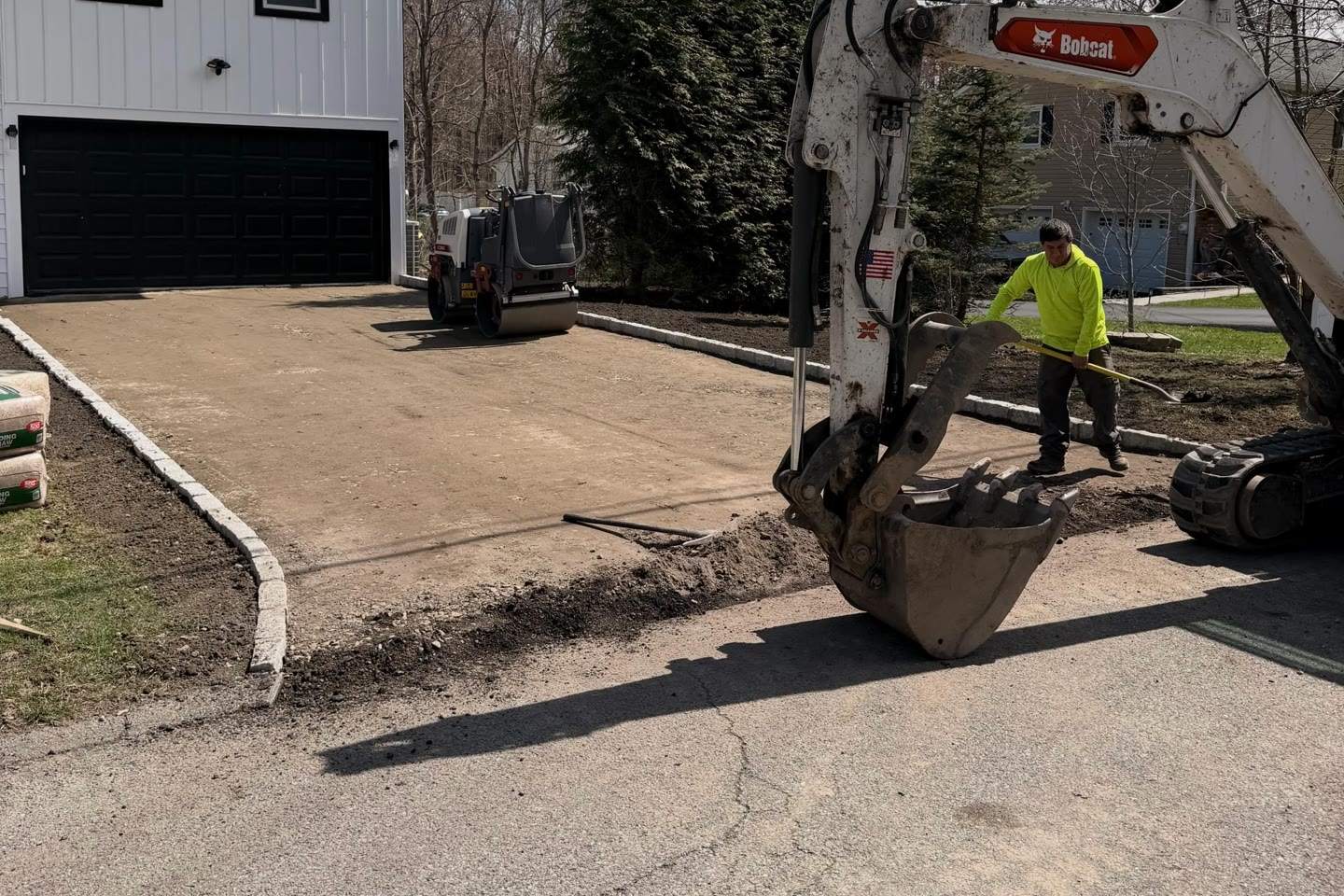 An excavator and a crew member preparing a new drive, a Luxuriad project
